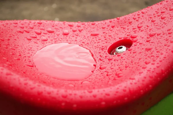 Wet swing seat close-up. Baby swing after rain.