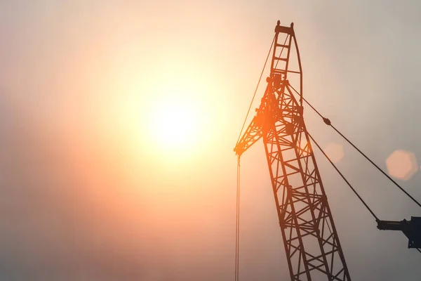 Una gru contro il cielo. Il sole è nella cornice. — Foto Stock