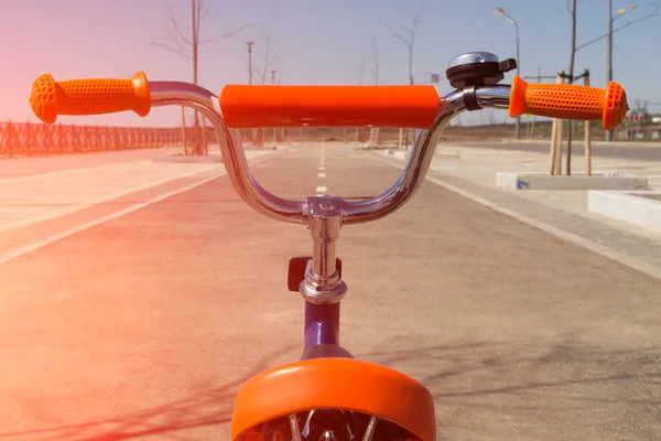 Un regard sur la route à travers le vélo. Vélo pour enfants dans la rue. — Photo