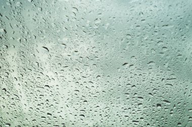 Soyut ve arka plan konsepti için muson mevsiminde cam pencereye yağmur damlası yağar.