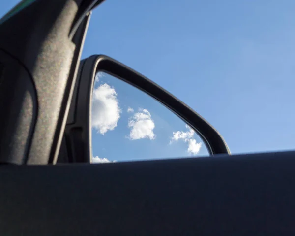 Road Car Rear View Mirror on a cloudy sky