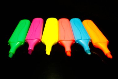 Siyah yakın plan üzerinde çok renkli kalem kapakları izole edildi