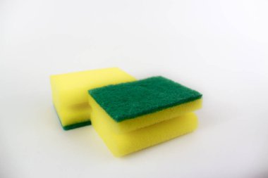 Beyaz arka planda izole edilmiş iki sarı yeşil mutfak süngeri.