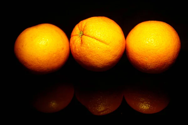Drei Orange Isoliert Auf Schwarz Mit Reflexion — Stockfoto