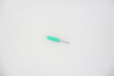 Beyaz arkaplanda yeşil duvar prizi vidası izole