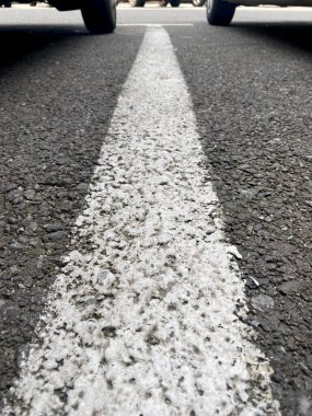 Arka planda iki tekerlek olan beyaz park şeridi.