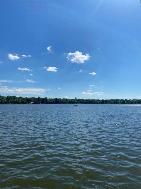 Göl manzaralı mavi gökyüzü ve arka planda ağaçlar