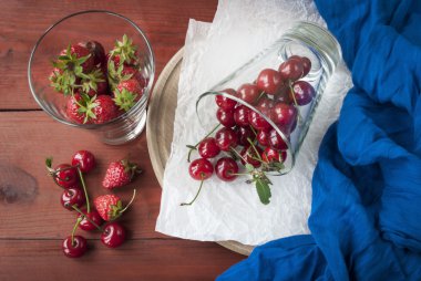 bir cam, çilek ve kiraz ahşap arka plan üzerinde taze çilek