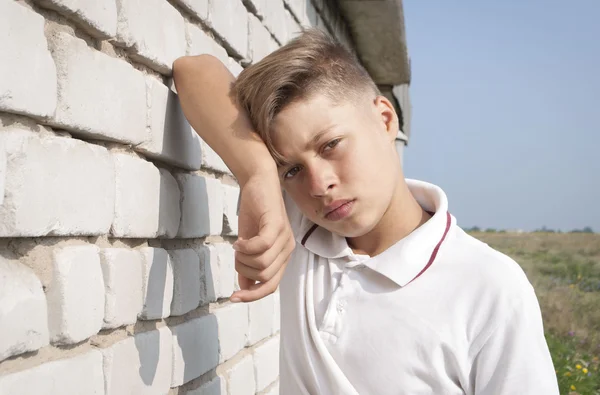 Portrait of young leaning against wall — Stock Photo, Image