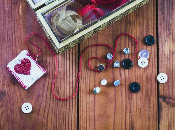 Needle , thread and buttons on a wooden table — Stock Photo, Image