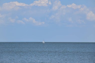 Tek başına deniz kenarında yüzen bir yat.