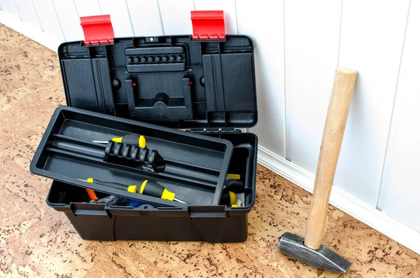 toolbox and a hammer near the wall