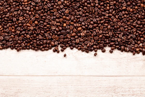 Grains de café avec un fond en bois — Photo