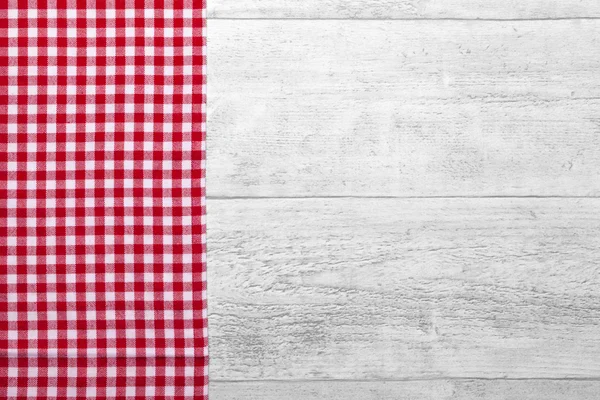 木製の背景を持つ赤い市松模様のテーブル クロス — ストック写真