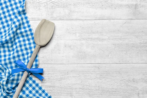 Blauw geblokte tafelkleed met een houten lepel — Stockfoto