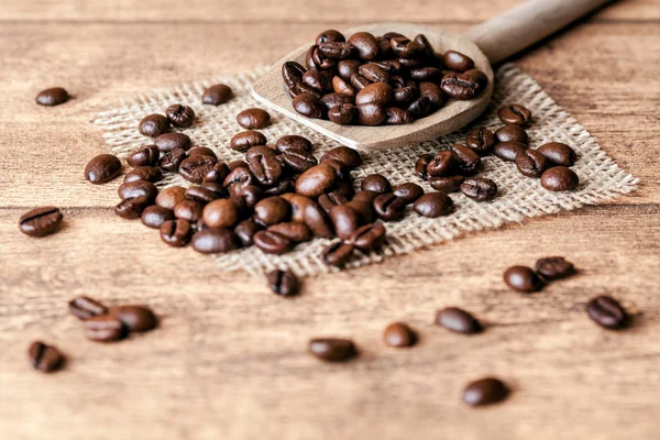 Grains de café avec une cuillère en bois — Photo