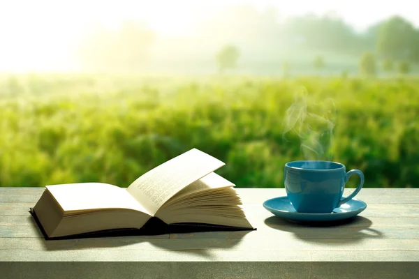 Libro abierto con una taza de café y una mesa de madera — Foto de Stock
