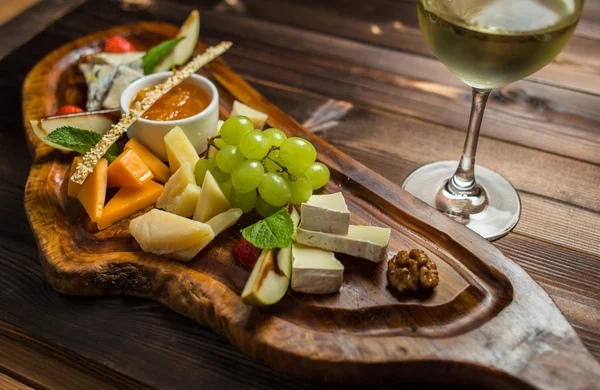 Fruit dish with white wine served on desk — Stock Photo, Image