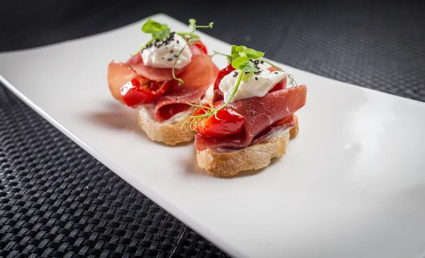 Bruschetta con parma en plato blanco — Foto de Stock