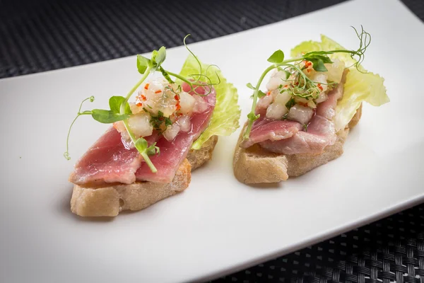 Bruschetta con atún sobre paladar blanco — Foto de Stock