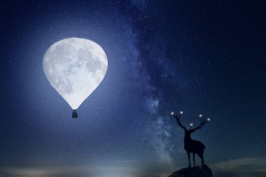 Bir geyikle büyülü yıldızlı gece. Dolunay balon şeklindedir.