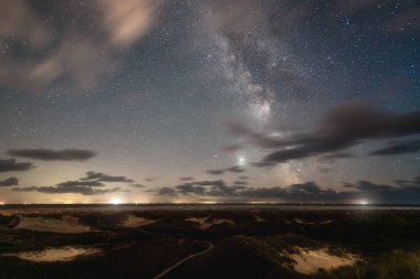 Bulutlar ve yıldızlı gökyüzü Samanyolu ile. Amrum kumul manzarası