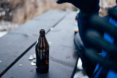 Adam dışarıdaki bira şişesine uzanıyor.