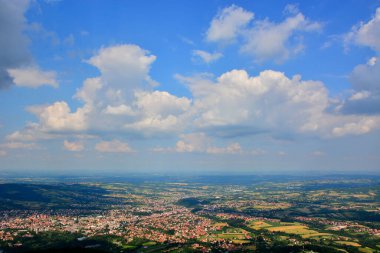 Yeşil tepeleri ve bulutlu gökyüzü ile güzel bir yaz manzarası.