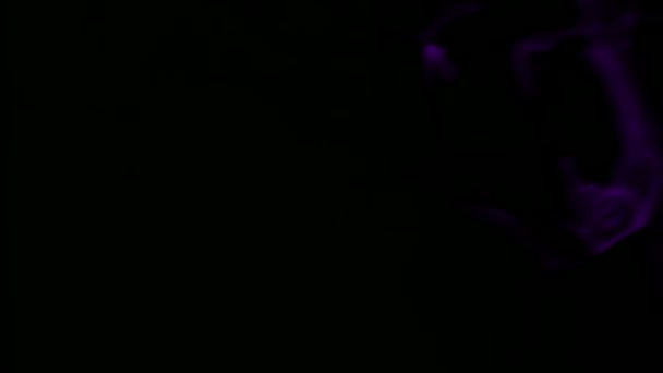Fumée violette sur fond noir .