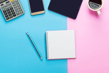 Ofis masası bilgisayar tableti, akıllı telefon pastel ton rengi, kopyalama alanı ve malzemeler. Kopyalama alanı olan üst görünüm