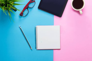 Ofis masası bilgisayar tableti, akıllı telefon pastel ton rengi, kopyalama alanı ve malzemeler. Kopyalama alanı olan üst görünüm