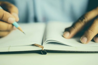 Defterde notlar alan kişi 