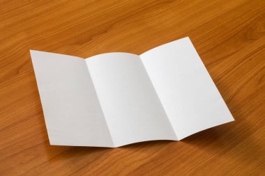 Beyaz modelleme, ahşap arka planda üç katlı broşür işi açtı.