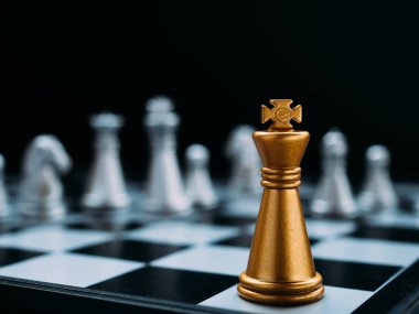 Satranç tahtası oyunu siyah arka plandaki tüm satranç taşlarına karşı duruyor. Strateji, Planlama ve Karar İş Konsepti