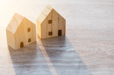 Ahşap zemin üzerine model ev. Yatırım sigortası ve ev satın alma konsepti.