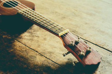 Ukulele 'yi eski ahşap arka planda kapat Vintage ton