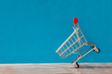 Mavi arka planda el arabası, alışveriş konsepti