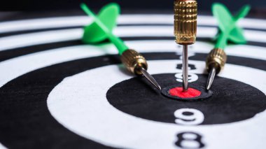 Siyah arkaplanda dart tahtasının ortasında kırmızı dart oku