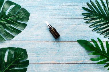 yeşil kozmetik losyon ve ahşap arka planda gerekli yağ şişesi