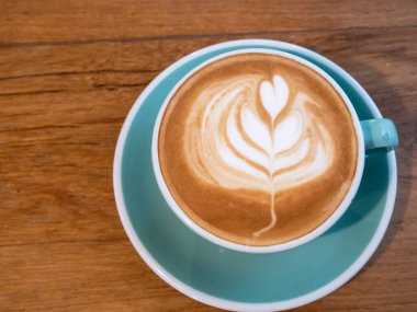 cappuccino bardağı ve masada sanat eseri.