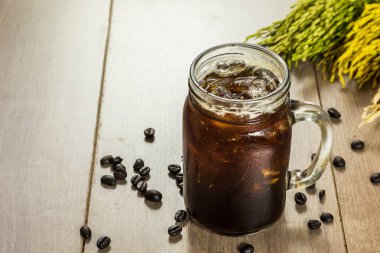 Sürahide buzlu kahve, kavanoz, masada bardak bardak.