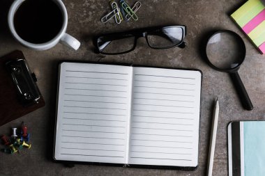 Ahşap üzerine defter kağıdı olan masa başı kahve bardağı.