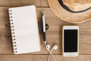 defter kağıdı ve cep telefonu ahşap masanın üstünde, üst görünümde.