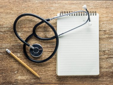 steteskop ve tahta üzerine defter kağıdı.