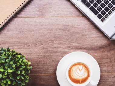 Ahşap üzerinde defter olan kahve fincanı.