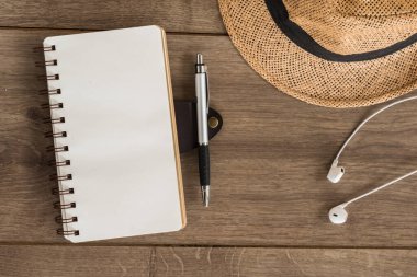 defter kağıdı ve cep telefonu ahşap masanın üstünde, üst görünümde.