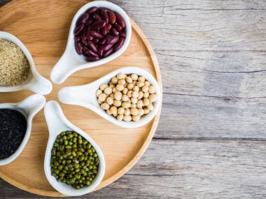 Tahta kaşıklarda kırmızı fasulyeler ve yeşil fasulyeler.