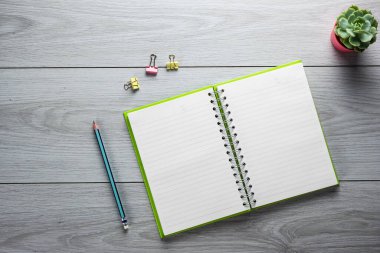 Boş defter, kalem, bir fincan kahve ve gözlüklü ofis masası. Kopyalama alanı olan üst görünüm