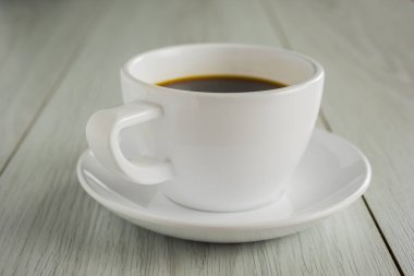 Beyaz fincan kahveyi tahtaya kapat.