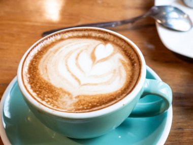 cappuccino bardağı ve masada sanat eseri.